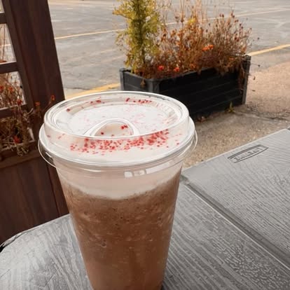 A blended fall drink with a dusted topping on the patio table
