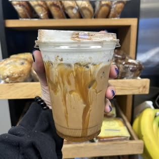 A caramel-drizzled iced drink held up by the pastry rack
