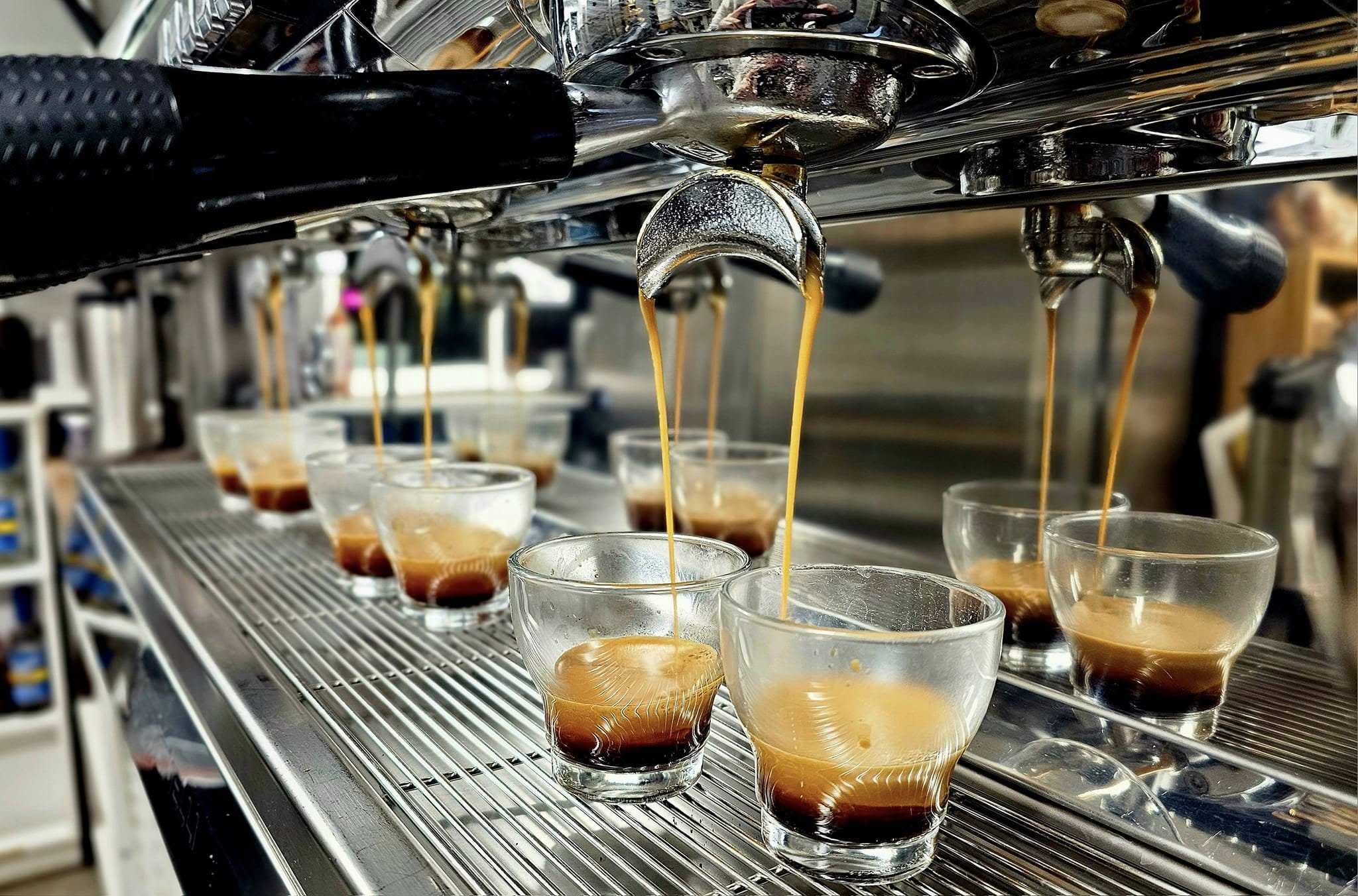 Espresso shots pulling on the machine into glasses