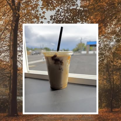 An iced drink framed on the windowsill with autumn trees behind