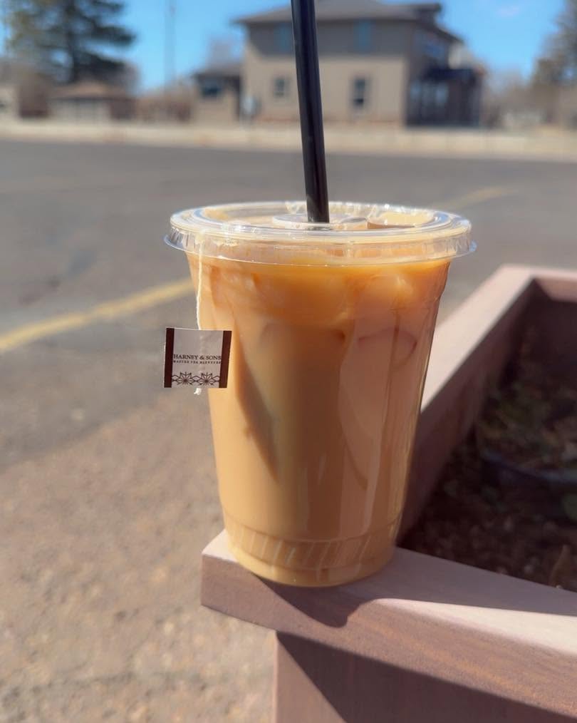 An iced coffee held roadside on Main with Vernal houses behind, on the way out of town